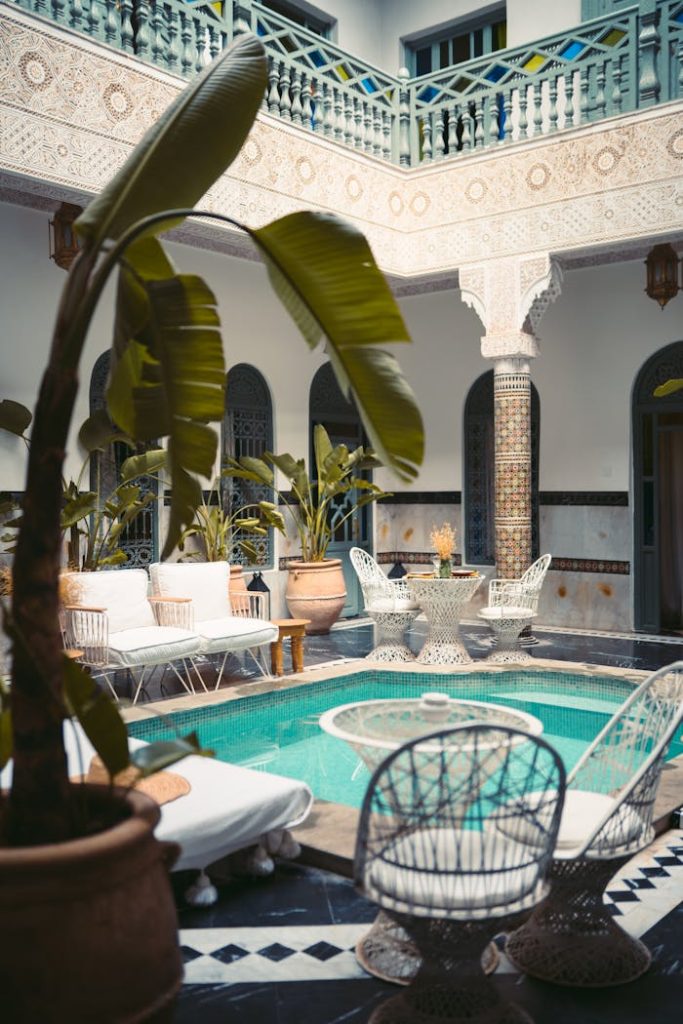 Luxurious Moroccan courtyard in Marrakesh with a pool and ornate decor.